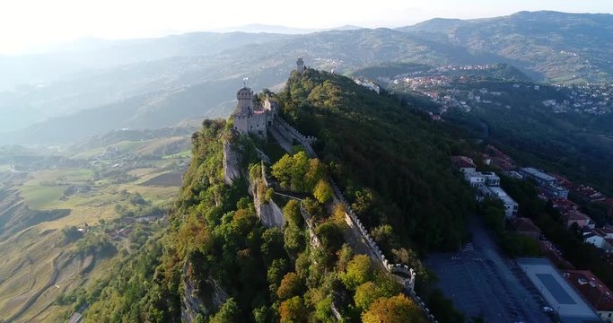 Mountain fortress, C4k aerial view over Cesta and Montale castles, on a sunny autumn day, at the three towers of San Marino