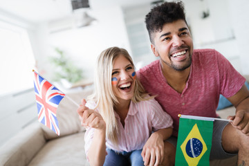 Young couple sport fans watching match cheering team