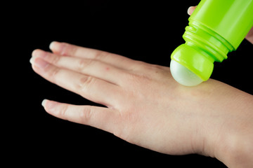 young woman puts on hand gel on black background