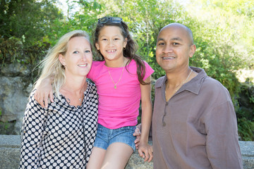 Mixed-race Happy family with little daughter girl in countryside