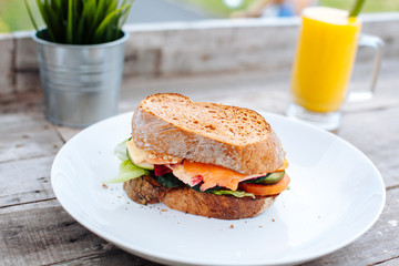 Healthy Breakfast with Wholemeal Bread toast and salmon, vegetables, cheese and fruit mango juice on the wooden background.