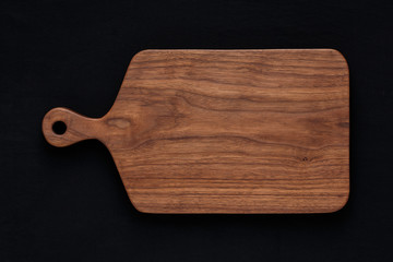 Handmade walnut wood chopping board on black cotton cloth