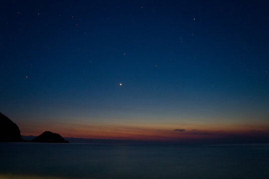 Motion blurred picture of a mediterranean sea at night under a beautiful sky with stars, seen from Petani beach on Cephalonia