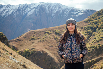 Naklejka premium beautiful girl stands on the background of mountains