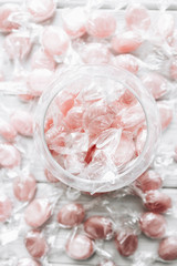 Pile of small pink sugar candies in glass