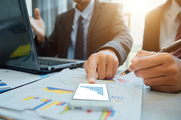 Business people partner negotiating a contract, they are pointing on a document and discussing together,Two businessmen are negotiating in office.