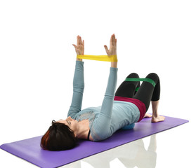 Woman exercising doing postnatal workout. Female fitness instructor working out with a rubber...