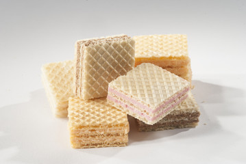 Wafer Cube shape biscuits with orange strawberry and chocolate flavor on a white background
