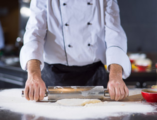 chef preparing dough for pizza with rolling pin