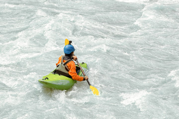 Kayaker paddling in white water rapids,  with copy space
