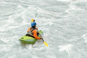 Fototapeta na wymiar Kayaker paddling in white water rapids, with copy space