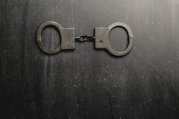 Metal handcuffs with dark background,