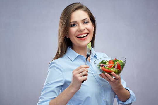 Smiling business woman eating healthy food, salad.