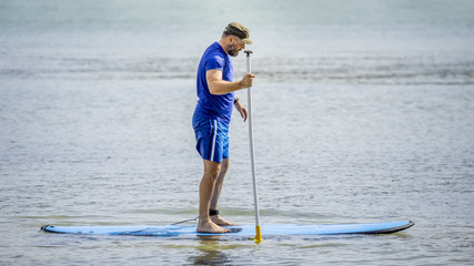 a bearded man paddling in the ocean