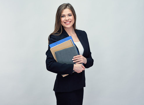 Smiling woman in black suit holding book and business paper.