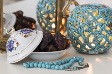 Date fruits,mirror and rosary on the white background with blue candle for Muslims Ramadan and three months concept.