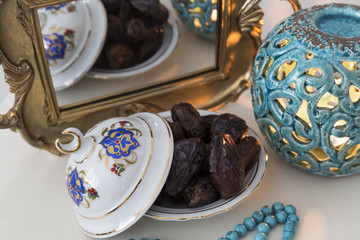 Date fruits,mirror and rosary on the white background with blue candle for Muslims Ramadan and three months concept.