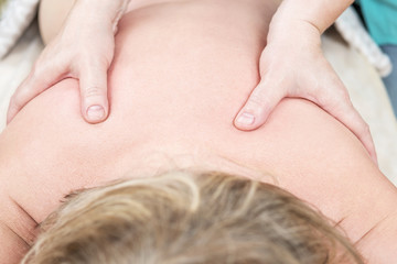 Thumbs of the massage therapist on the patient's back, close-up