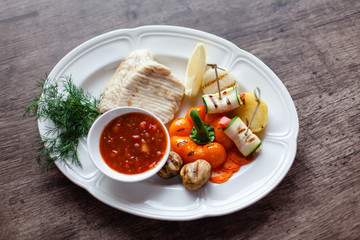 grilled fish fillet served with vegetables and sauce