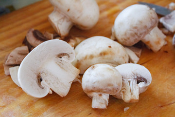 Champignon mushrooms, sacking mat and spices on wooden background