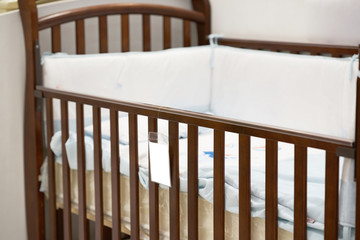 Empty crib with pillow and price slip label