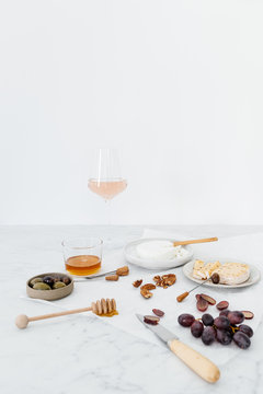 Food table with delicious cheese platter and wine on a marble table.