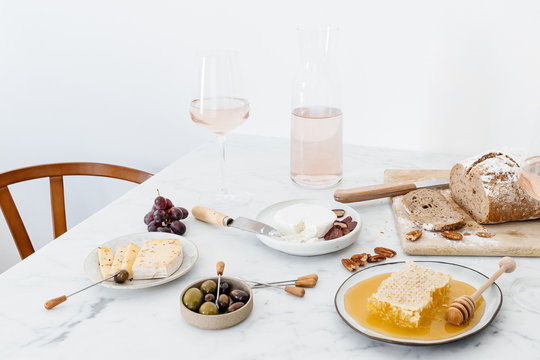 Table setting with extensive cheese platter on a marble table.
