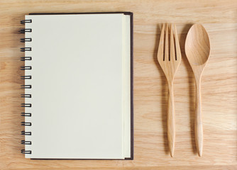empty wood plate with notebook open and spoon ,frok