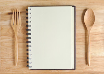empty wood plate with notebook open and spoon ,frok
