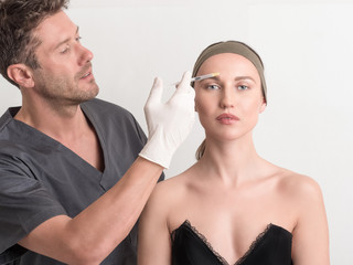 Expert beautician injecting botox in female face.