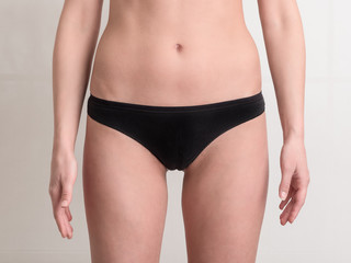 Young woman body with black panties on white background.