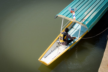 A young Asian backpacker tourist is enjoying a boat ride on the river.Holidays and nature concepts