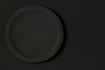 View of a round wooden plate on a black board