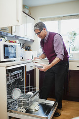 Mature Man Unloading the Dishwasher