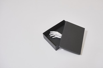 black gift box with lifeless model white hand isolated