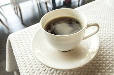 cup of coffee over white table background