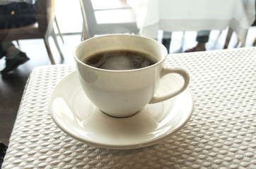 cup of coffee over white table background