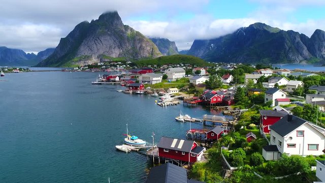 Aerial footage of small fishing village of Hamnoy on Lofoten islands in Norway, popular tourist destination with its typical red houses and natural beauty. Aerial 4k Ultra HD.