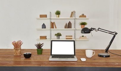 Decorative office room and table style with laptop and bookcase.