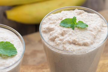 Chocolate banana smoothie in a glass on wood