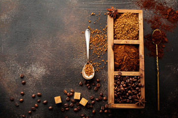 Food background with three kinds of coffee: beans, milled, instant in wooden box on old concrete...