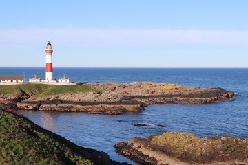 Red and white lighthouse on island