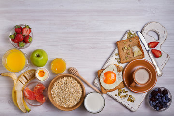 Obraz na płótnie Canvas Breakfast served with coffee, orange juice, cereals, milk, fruits, eggs and toasts. Balance diet, food banner, background. View from above, top
