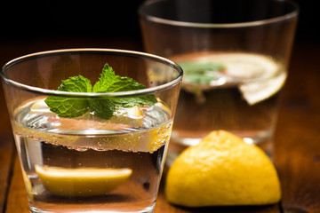 Lemonade with fresh lemon on wooden background