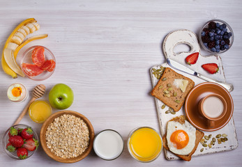 Fototapeta na wymiar Breakfast served with coffee, orange juice, cereals, milk, fruits, eggs and toasts. Balance diet, food banner, background. View from above, top