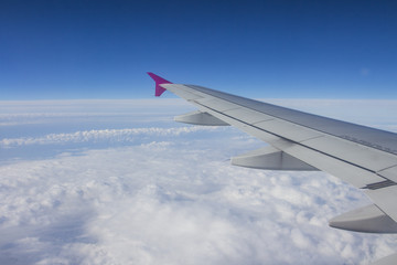 Obraz premium The wing of the plane in the clouds