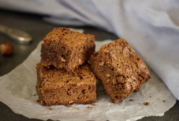 Three pieces of chocolate biscuit with hazelnut on paper