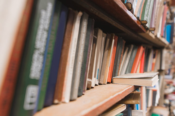 Background. Old books on book shelves. Books in the old atmospheric library.