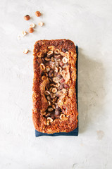 Pumpkin espresso bread with hazelnuts on a blue napkin on a white stone background. Top view and copy space.