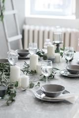 Table setting. Candles, plates and glasses